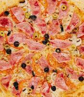 Italiaans snel voedsel. heerlijk heet pizza met ham en champignons gesneden foto