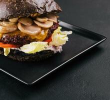 zwart hamburger met rundvlees en champignons foto