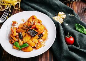 Italiaans traditioneel pasta met aubergine, tomaat en kaas foto