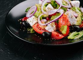 Grieks salade in zwart kom Aan steen foto