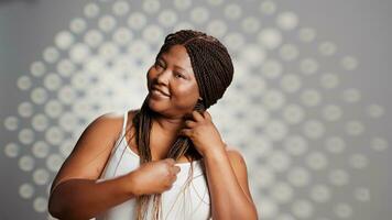 Afrikaanse Amerikaans meisje poseren met tederheid en kaal huid, creëren huidsverzorging campagne voor vlekkeloos gloeiend teint. schoonheid model- bevorderen advertentie voor natuurlijk stralend huid in studio. foto