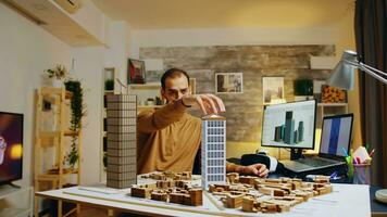 architect modellering gebouwen in huis kantoor leven kamer, in aansluiting op 3d grafisch ontwerp schetsen plannen Aan computer scherm. professioneel werken Aan skyscrapper structuur maquette foto