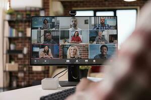 detailopname van computer scherm met video telefoontje software app tonen team van collega's in conferentie brainstorming ideeën. Afrikaanse Amerikaans opstarten werknemer in internet vergadering met mensen werken op afstand. foto