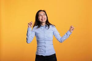 vrolijk Filipijns vrouw dansen en hebben pret gedurende vrije tijd tijd in studio over- geïsoleerd achtergrond. blij glimlachen model- genieten van tonen haar dans beweegt gedurende werk pauze. vermaak concept foto