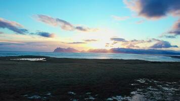 arctisch landschap van zwart zand strand in IJsland, Scandinavisch landschap van besneeuwd heuvels en verkoudheid water. majestueus nordic landschap Aan kustlijn met oceaan getijden en golven. handheld schot. foto
