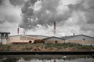 industrie fabriek Oppervlakte vuil lucht en water verontreiniging afvoer verspilling water en rook schoorsteen Gevaar voor milieu en ecologie foto