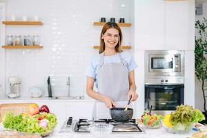 portret gelukkig vrouw genieten glimlachen Koken voedsel heet soep Bij huis keuken aan het leren gezond groenten koken foto