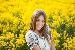 mooie vrouw tussen gele bloemen in een veld