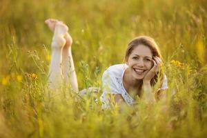 gelukkig meisje dat in het gras ligt foto