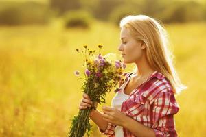 blij meisje met een boeket wilde bloemen foto