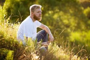 man zittend op het gras foto