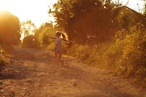 gelukkig meisje loopt langs een landweg