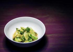 Aziatische verse komkommer, gember en zoete sesam sojasaus fusion gastronomische salade foto