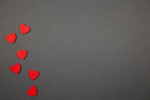 rood harten confetti Aan donker achtergrond. valentijnskaarten, moeders, vrouwen dag, bruiloft of verjaardag vlak leggen concept. top visie. kopiëren ruimte. foto
