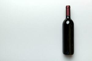 een fles van rood wijn Aan gekleurde tafel. vlak leggen, top visie wth kopiëren ruimte foto