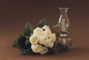 klassiek wit roos boeket en oud gas- lamp Aan bruin achtergrond.. wijnoogst decor stijlvol. foto