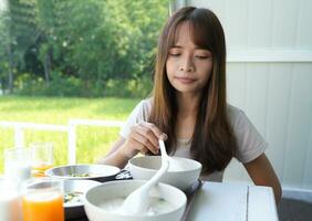 Aziatisch vrouw toeristen aan het eten ontbijt foto