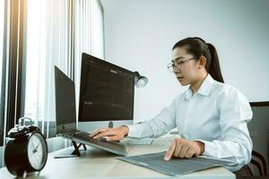 vrouwelijke aziatische softwareontwikkelaars analyseren samen over de code die in het programma op de computer in de kantoorruimte is geschreven. foto