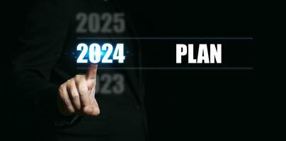 nieuw jaar 2024 met plannen. zakenman richten naar de getallen van de jaar naar reeks doelen en maken plannen voor de komt eraan jaar. foto