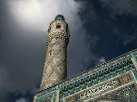minaret van de moskee tegen een dramatisch lucht. foto