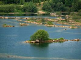 groot water lagune. eiland in de midden- van de rivier- met bomen bedekt. een oud steengroeve overstroomd met water. foto