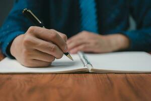 hand- Holding pen checklist papier werk Aan bureau. ondertekening informatie contract en overeenkomst. checkbox verslag doen van vragen klant Diensten. schrijven onderwijs en aan het leren huiswerk. foto