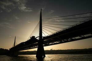 silhouet van de metro brug Bij de gouden Hoorn, Istanbul in zonsondergang foto