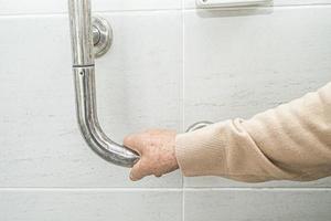 Aziatische senior vrouw patiënt gebruik toilet badkamer handvat beveiliging foto