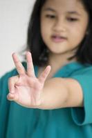 een jong meisje dat nummer telt met haar vingers foto