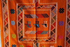 een oranje tapijt met kleurrijk ontwerpen Aan het foto