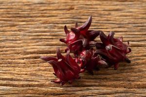 roselle helder glas met vers roselle fruit op houten tafel foto