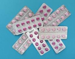 roze tabletten in blisters op blauwe achtergrond foto