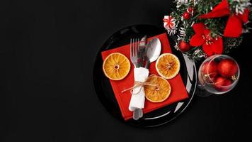 setting voor feestelijk kerstdiner op zwarte tafel met decoratie