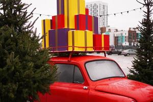 kerst rode retro auto met geschenkdozen buiten foto