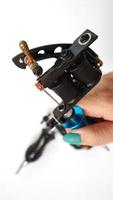 tattoo machine op tattoo artiest hand op witte achtergrond foto