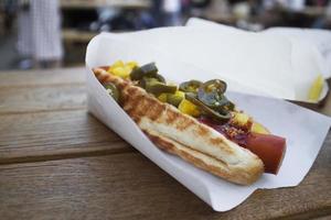 hotdog met gegrilde worstjes, uien en groenten foto
