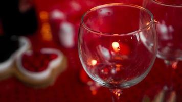 leeg wijnglas op liefdesdiner, kaars op rode achtergrond foto
