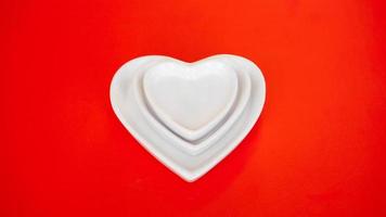 hartvorm witte platen op rode achtergrond foto