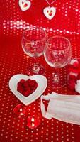 Valentijnsdag concept tafel. romantisch diner met medisch masker foto