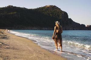 vrouw op het strand in een bruine jurk