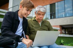 gefocust jong studenten luisteren oud senior oud leraren voor adviseren sluitsteen project in Universiteit. gelukkig midden- oud leraar werken samen met studenten voor diploma uitreiking project. foto