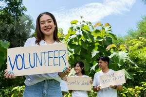 gelukkig jong Aziatisch studenten verschillend vrijwilligers houden een campagne teken voor schoonmaak in de park, de concept van milieu behoud Aan wereld milieu dag, recyclen, liefdadigheid voor duurzaamheid. foto