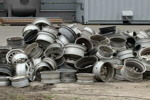 oud auto velgen stapel Bij schroothoop autokerkhof. stack van oud weggegooid wielen, metaal recycling industrie. foto