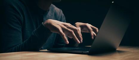 hacker gebruikt de laptop om virussen of malware te coderen voor het hacken van de server foto