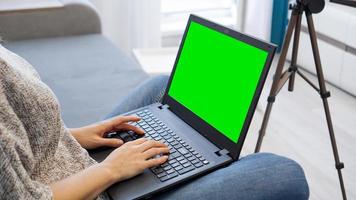 zicht op camera op statief en laptop met greenscreen chromakey foto