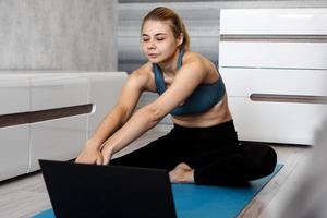 vrouw in sportkleding kijken naar online video op laptop foto