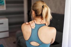 sportblessure concept. atletisch meisje voelt pijn in haar nek foto