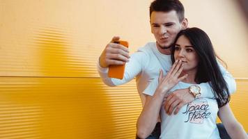 jonge mooie paar selfie maken op smartphone over gele achtergrond foto