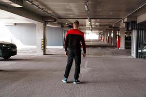 een jonge man in een sportuniform in een ondergrondse parkeerplaats. foto