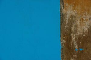 oud beton met bruin gips muur gedeeltelijk geschilderd in blauw, structuur en achtergrond foto